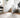 Ivory and pebble Loloi Rugs Sienne SIE-01 rug with intricate pattern, displayed on a wooden floor in a cozy room setting.
